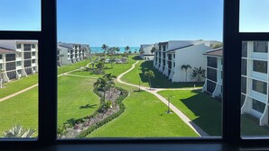 Uitzicht op een hotel met meerdere gebouwen, een verzorgd gazon en een helderblauwe lucht.
