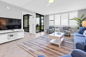 En moderne stue med et fladskærms-tv, et sofabord og en sofa.