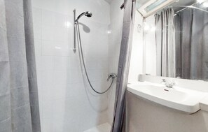 A modern bathroom with a shower, a sink, and a mirror. - Charmante maison proche plage (Royan)