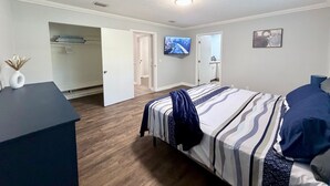 Un dormitorio con cama, escritorio, televisor y armario.