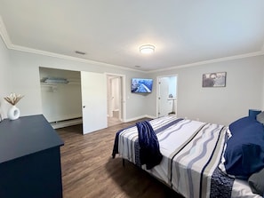 A bedroom with a bed, a desk, a TV, and a closet. - Alderman Acres - 4 Bedroom with a Game Room! (Jacksonville)