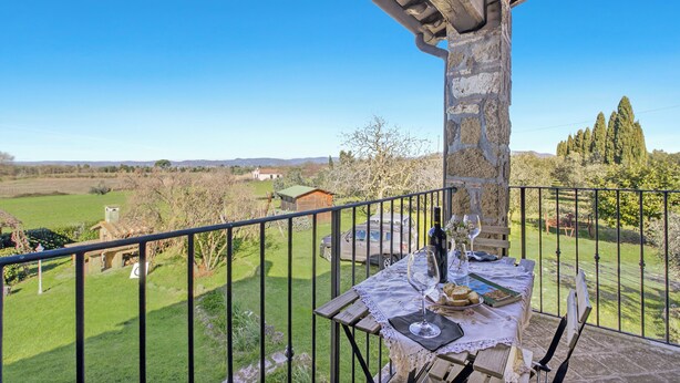 A balcony with a table set for dining, overlooking a rural landscape with fields and trees. - Casale Le Sorgenti - Farmhouse with Pool for 8, Pitigliano, Italy (Pitigliano)