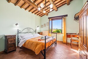 A bedroom with a bed, a desk, and a view of the outdoors. - Casale Le Sorgenti - Farmhouse with Pool for 8, Pitigliano, Italy (Pitigliano)