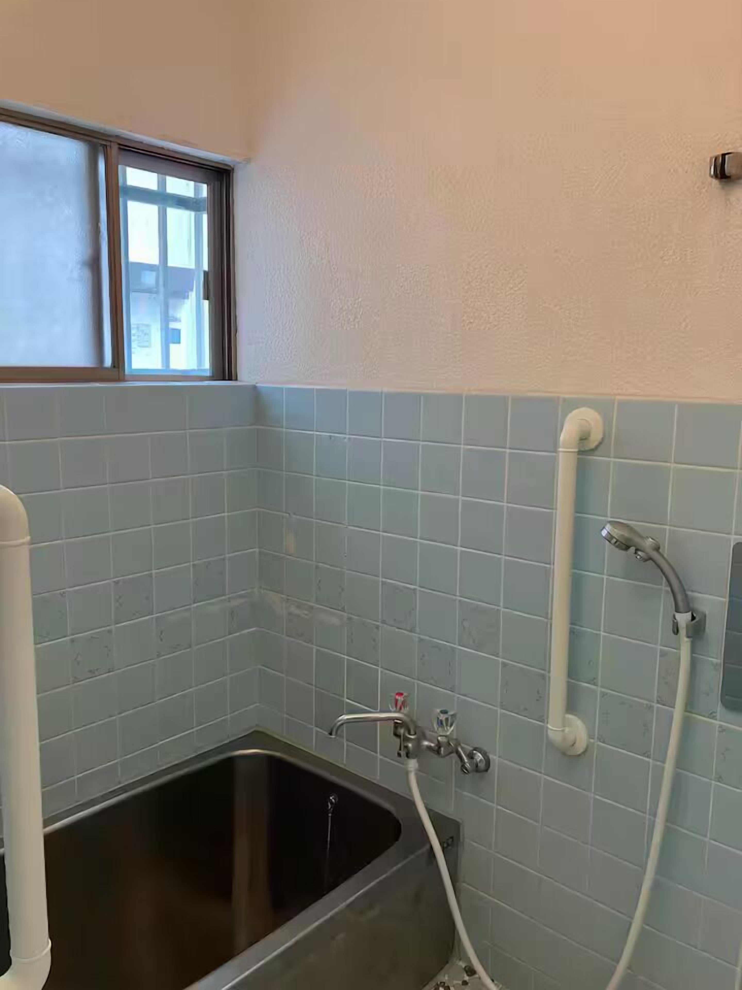 Un baño con bañera, ventana y ducha.