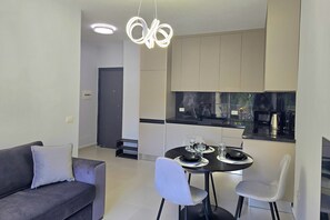 Eine moderne Küche mit Essbereich, einer Couch und einem Tisch für zwei Personen.