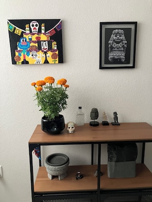 A wooden table with a potted plant, a skull, and small figurines.