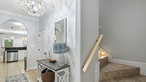Un intérieur moderne comprenant une cuisine, une console avec une lampe et un escalier.