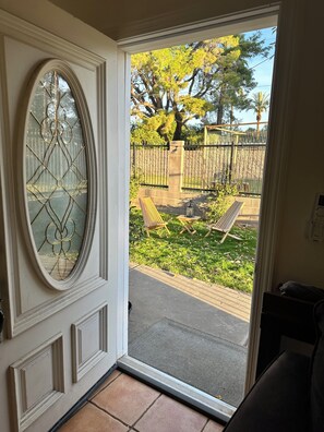 A door with a decorative glass panel and a view of an outdoor patio with a bench and a table. - Peaceful Mesa studio - minutes to spring training (Mesa)