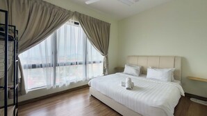 A hotel room with a bed, a ceiling fan, and a large window with curtains. - Family 2BR Apartment, Melaka City (Malacca City)