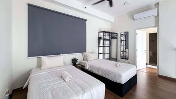 A modern hotel room with two beds, a ceiling fan, an air conditioning unit, and a large mirror.
