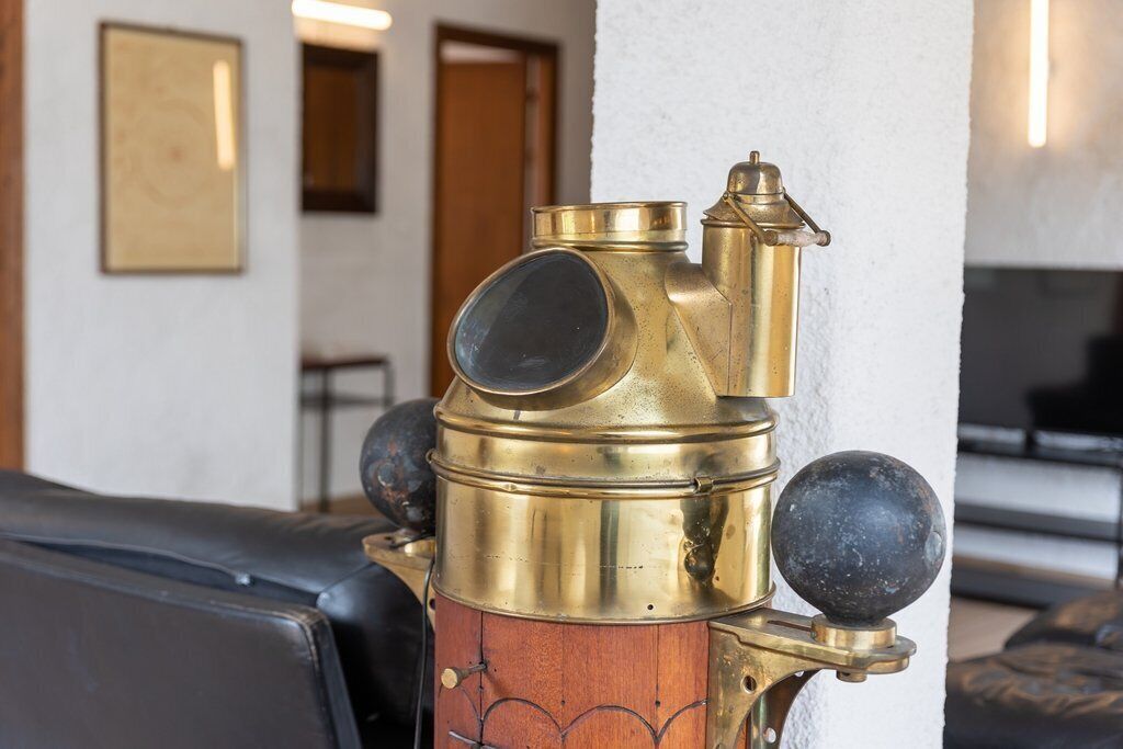 Um telescópio de latão com detalhes em madeira fixado na parede.