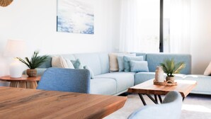 A modern living room with a sofa, a coffee table, and a dining table. - Villa Oronella with Saltwater Pool, Premium Comfort & Elegant Design (Puigderros (Llucmajor))