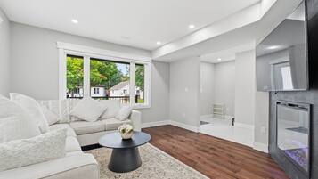 Una sala moderna con sofá, mesa de centro y vistas al exterior.