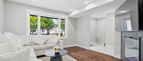 A modern living room with a sofa, coffee table, and a view of the outside.