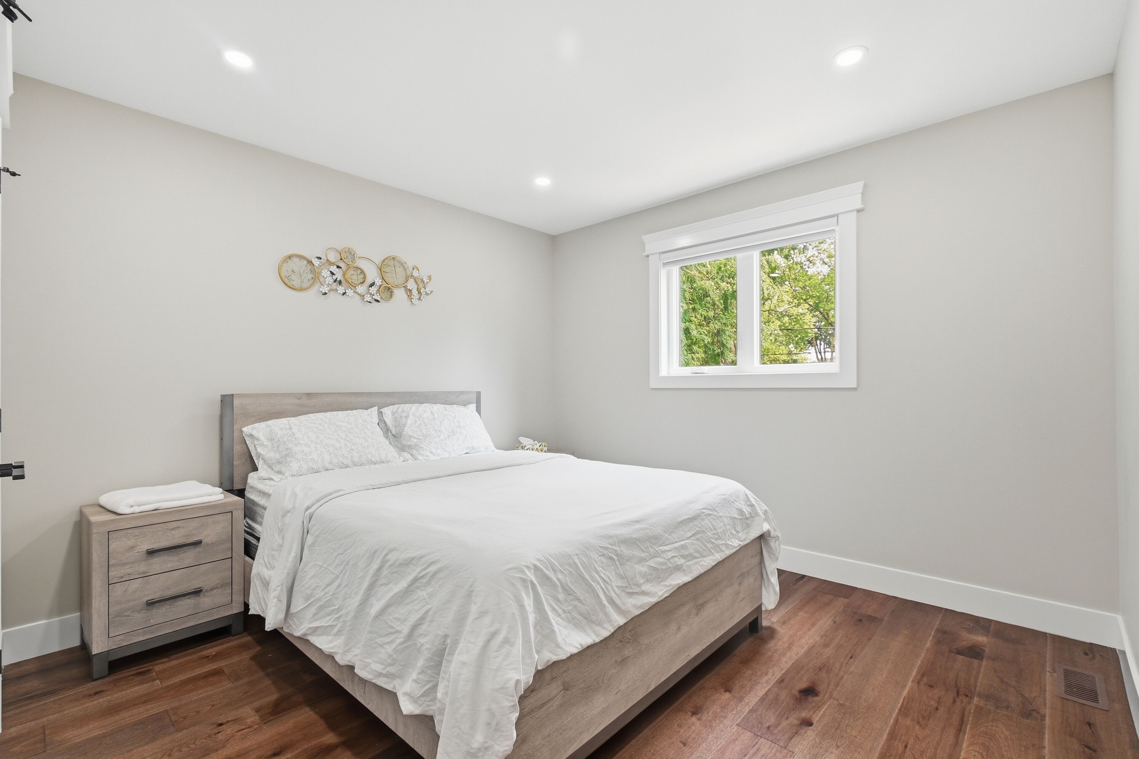 Une chambre à coucher avec un lit, une table de chevet et une horloge murale.