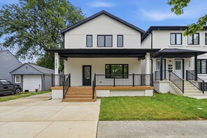 A two-story residential building with a front porch, a driveway, and a lawn. - Premium Windsor Retreat |Perfect for Families, Groups & Long Stays+ Free Parking (Windsor)