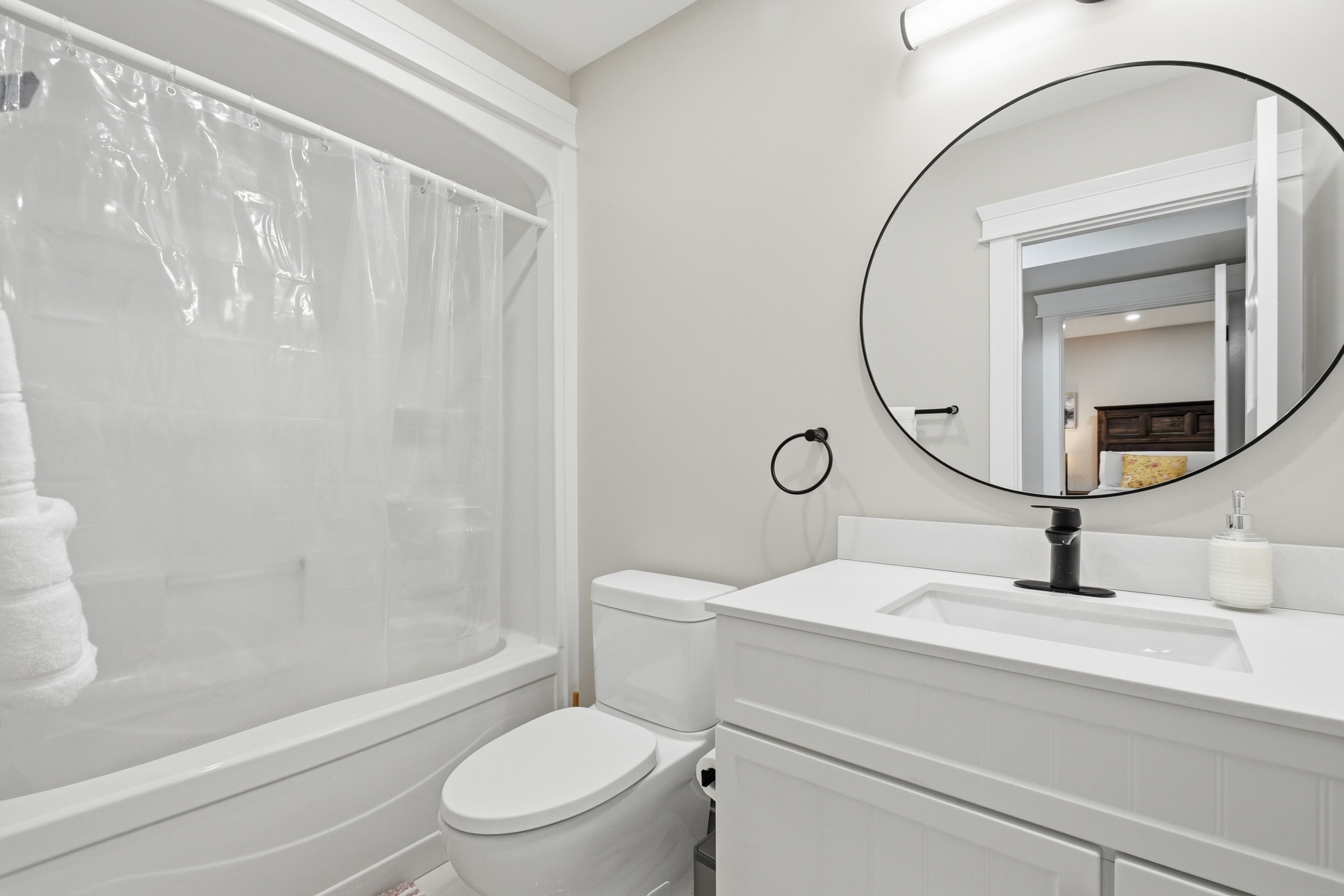 A bathroom with a bathtub, toilet, and sink.