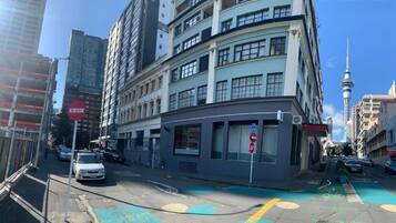 A multi-story building with a 'No Entry' sign, a bike lane, and a view of a tower in the background.