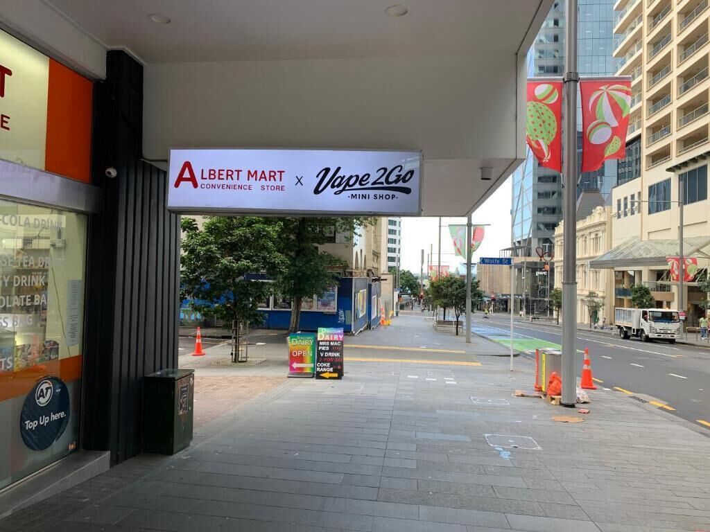 A storefront with a sign for Albert Mart Convenience Store and Vape 2Go Mini Shop.