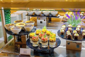 A buffet with various desserts and a sign indicating 'LUGANO' and 'Mango'.