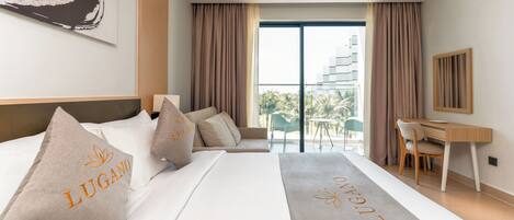 A hotel room with a bed, a desk, a chair, a large window, and a view of buildings.
