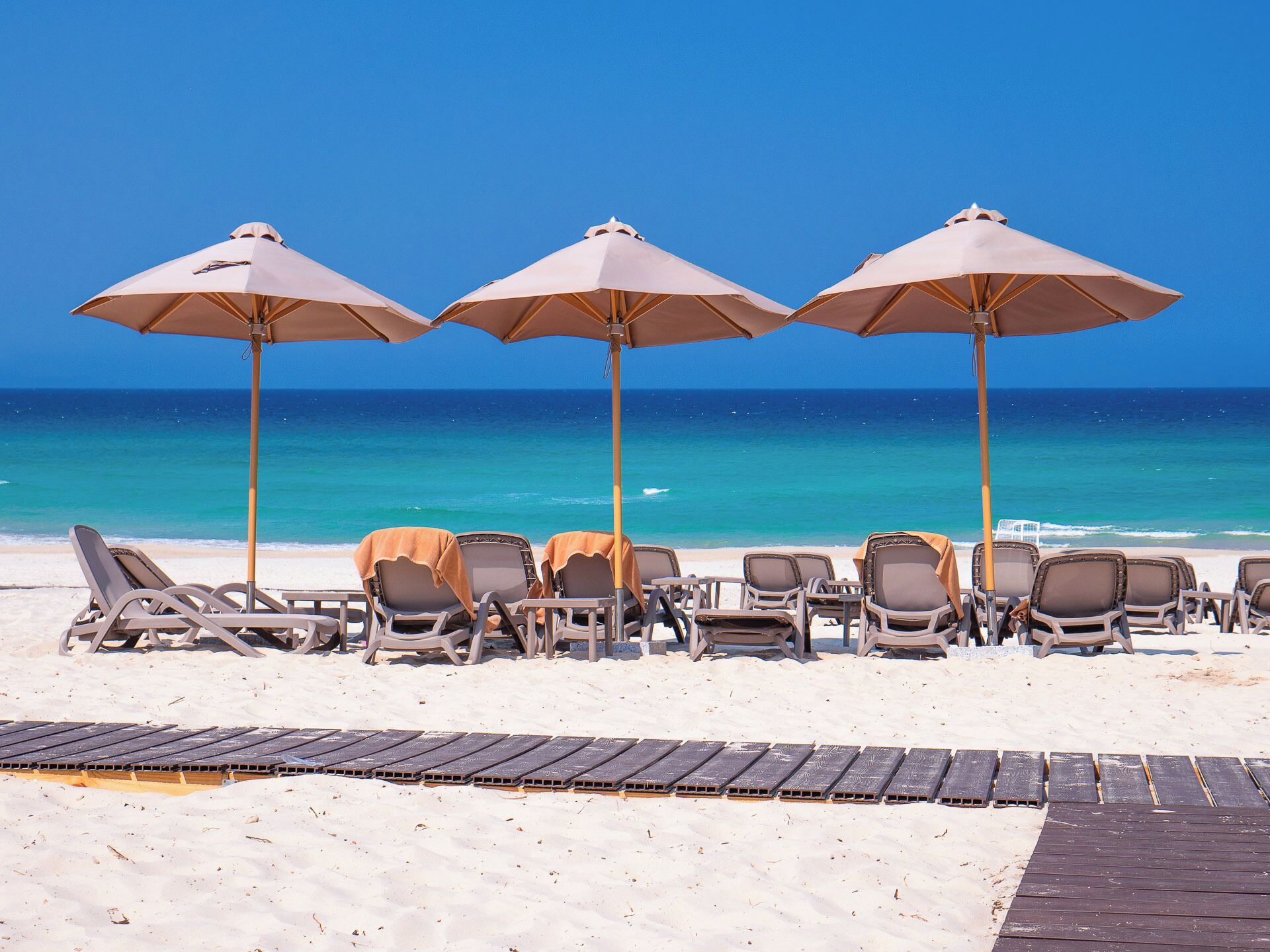 Plage privée, sable blanc, parasols, serviettes de plage