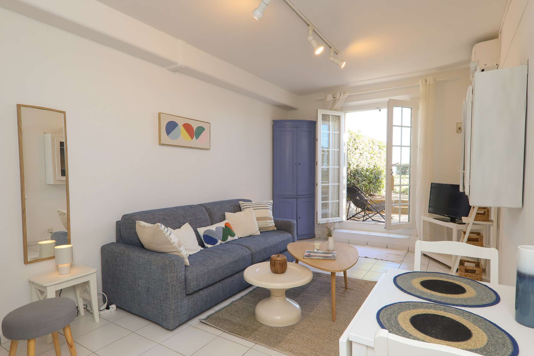 Un salon moderne avec un canapé, une table basse et un téléviseur.