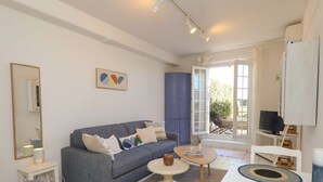 Ein modernes Wohnzimmer mit Sofa, Couchtisch und Fernseher.