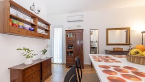 A kitchen with wooden cabinets, a dining table, and a mirror. - La Barca Open Space - Goelba (Marciana Marina)