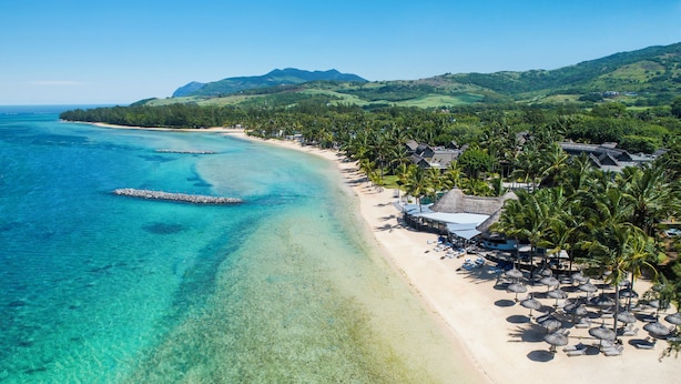 A beach resort with clear turquoise waters, a sandy shore, and a backdrop of green hills. - Elegant 3-Bedroom Villa / Sea View & Bel Ombre Setting (Bel Ombre)