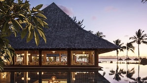 A resort with a pool, a building with large windows, and palm trees. - Elegant 3-Bedroom Villa / Sea View & Bel Ombre Setting (Bel Ombre)