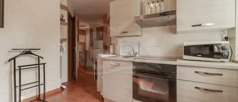 A modern kitchen with a microwave, oven, and stainless steel cabinets.