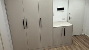 A room with a large wardrobe, a small desk, and a door. - Najli apartments (Tiranë)