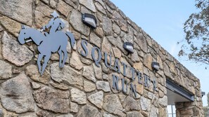 A stone wall with a sign reading 'SQUATTER'S RUN' and a silhouette of a person on a horse. - Squatters Run 26 in the Heart of Thredbo (Thredbo)