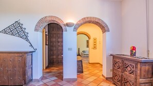 Un pasillo con suelo a cuadros, armarios de madera y puertas en arco.