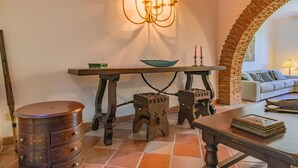 Un interior tradicional con una mesa de madera, un candelabro y un arco de ladrillo rústico.