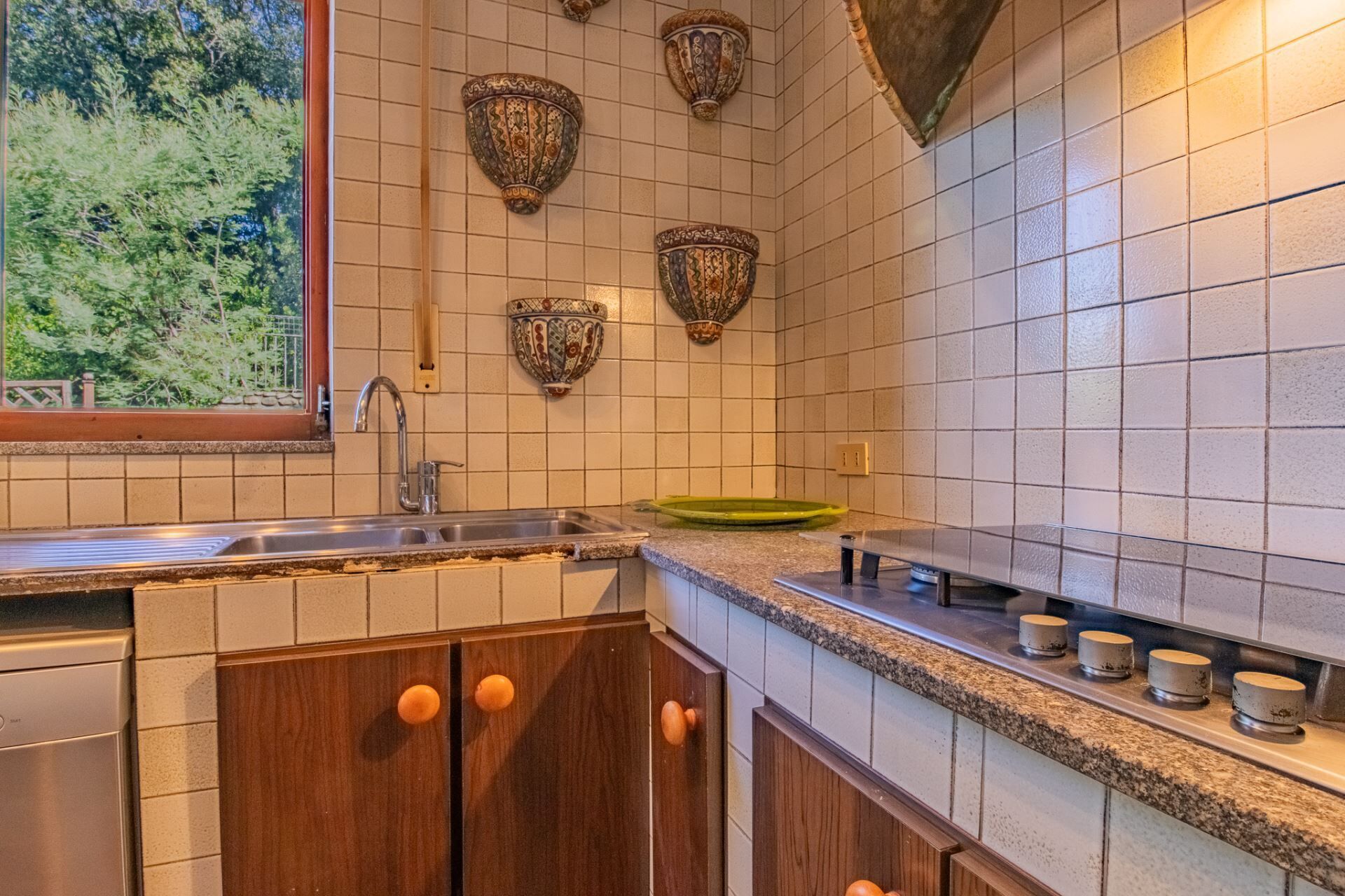 Una cocina con un lavamanos, encimera y armarios de madera.