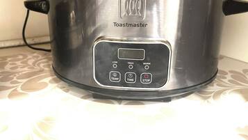 A stainless steel Toastmaster slow cooker with a digital control panel.