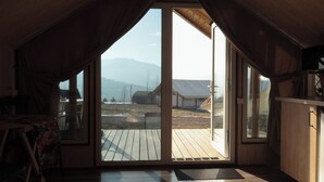 Una habitación con un amplio ventanal corredero que da a una terraza exterior.
