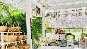 Un marché en plein air abrité, avec des étagères remplies de paniers tressés et une exposition de textiles aux couleurs vives.