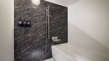 Un baño moderno con pared de mármol, ducha, bañera y estante para dispensador de jabón.