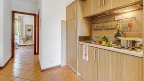 A kitchen with wooden cabinets, a sink, and a stove. - Residence La Perla - Apt 19 (Monte Isola)