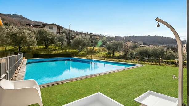 A swimming pool with a clear blue water, surrounded by a well-maintained lawn and olive trees. - Residence La Perla - Apt 19 (Monte Isola)