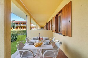 A dining area with a table set for two, a bottle, and bread. - Residence La Perla - Apt 17 (Monte Isola)