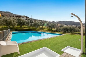 A swimming pool with a clear blue water, surrounded by a well-maintained lawn and olive trees. - Residence La Perla - Apt 18 (Monte Isola)