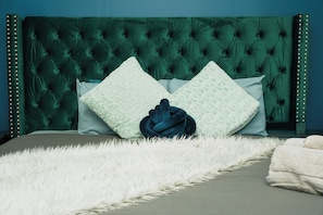 A bed with a tufted headboard, two pillows, and a fluffy white throw. - Luxury Lakeview Stay with Jacuzzi | Downtown Barrie (Barrie)
