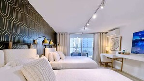 Ein Hotelzimmer mit zwei Betten, einem Schreibtisch, einem Stuhl und einem großen Fenster mit Blick.