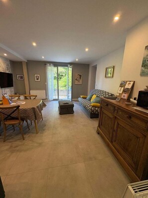 A spacious living area with a dining table, sofa, and a cabinet.