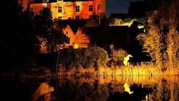 Un bâtiment qui ressemble à un château, avec de nombreuses tours et un fossé.