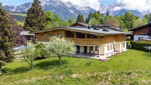 Une maison de style chalet, avec un toit en pente, un revêtement extérieur en bois et un balcon.